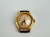 a gold watch with a black band on a white surface