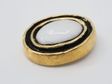 an image of a close up of a gold and white broochle