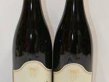 deux bouteilles de vin posées sur une table l'une à côté de l'autre