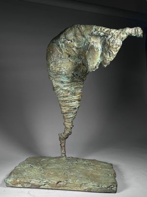 bronze sculpture of an elephant standing on a rock with its trunk in the air
