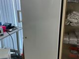 un réfrigérateur blanc à côté d'un placard dans une pièce