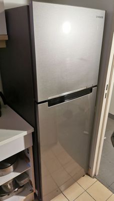 a refrigerator in the corner of a kitchen next to a sink