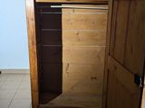 a wooden cabinet with a door open in a room