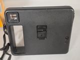a black camera sitting on a table with a strap around it