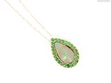 a close up of a necklace with an oplite and emerald pendant