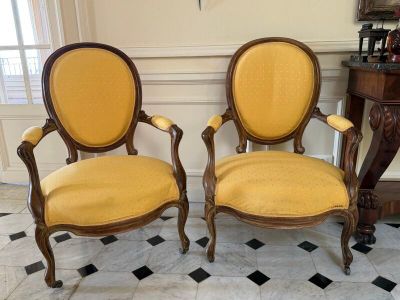 une paire de fauteuils rembourrés jaunes dans une pièce au sol à carreaux noirs et blancs