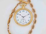 a gold pocket watch on a chain with a chain around it