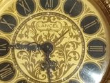 a gold clock with roman numerals on the face