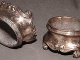 two silver cups sitting on a table next to each other
