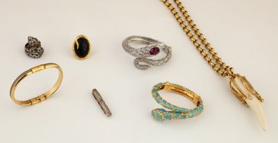 several rings, bracelets, and other jewelry on a white surface