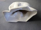 a white porcelain shell with a large open mouth