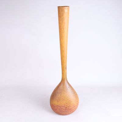 un vase orange muni d'une poignée en bois, posé sur une surface blanche