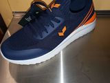 des chaussures de course bleu marine et orange posées sur une surface métallique