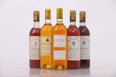 four bottles of wine are lined up in a row on a white surface