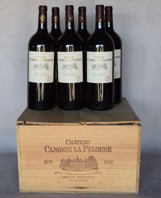 three bottles of wine are in a wooden box on a table
