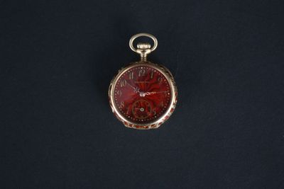 gros plan d'une montre de poche sur une surface noire