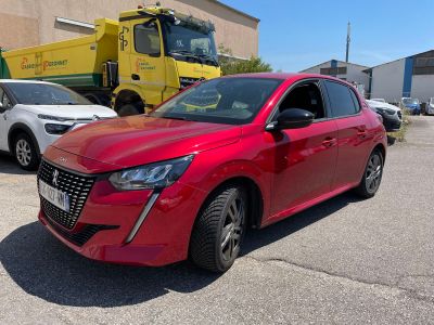 a red car parked in a parking lot next to a yellow truck