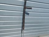 a metal pole that is leaning against a garage door