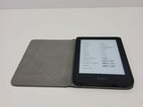 a kindle that is sitting on a table next to a book