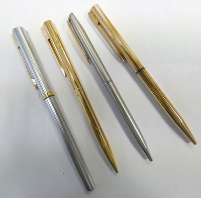 three different types of pens sitting on top of a white surface
