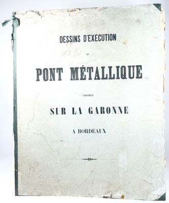 un vieux livre posé sur une table à côté d'un mur blanc