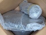 a cardboard box filled with plastic wrap and pillows
