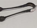 une paire de cuillères anciennes en argent posées sur une surface blanche
