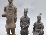 trois figurines en argile représentant un homme et une femme assis sur des blocs