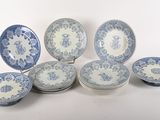 Plusieurs assiettes et bols bleus et blancs sont disposés sur une surface blanche