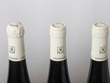 three bottles of wine are lined up on a table