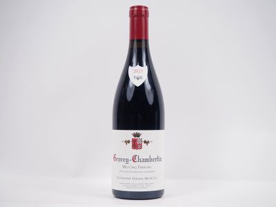 une bouteille de vin rouge posée sur une table blanche
