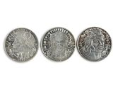 three different types of silver coins on a white surface