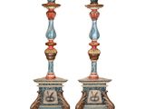 pair of painted candlesticks with a bird on top of them