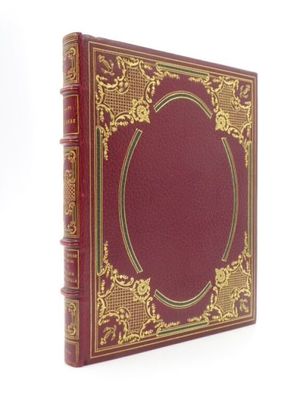 un vieux livre rouge aux tranches dorées et à la bordure dorée