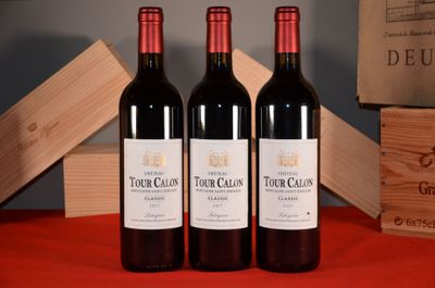 three bottles of red wine sitting on a table next to a wooden box