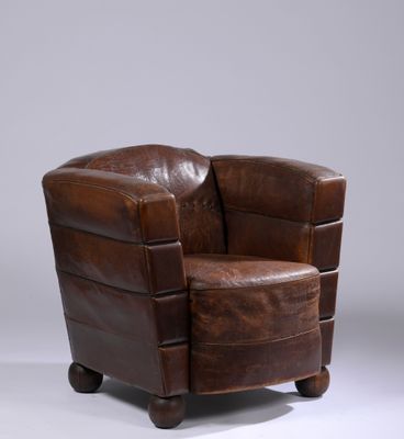 a brown leather chair sitting on top of a white floor