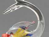 glass figurine of a fish with a long tail on a gray background