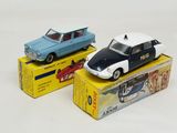 two toy cars sitting on top of boxes on a white surface