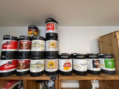 Plusieurs fûts de bière sont empilés sur une étagère dans une pièce
