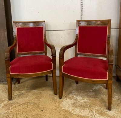 une paire de fauteuils rembourrés rouges placés l'un à côté de l'autre dans une pièce