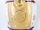 a gold vase with a blue and white design on it