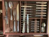 a wooden box with silverware in it on a table