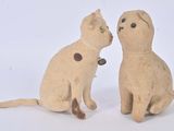 deux chats assis l'un à côté de l'autre sur une surface blanche