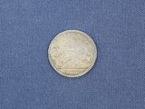 a close up of a silver coin on a blue cloth
