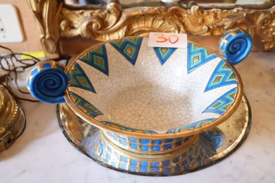 un bol bleu et blanc posé sur une table à côté d'un miroir