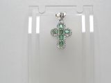 un gros plan d'un pendentif en forme de croix dans une vitrine transparente