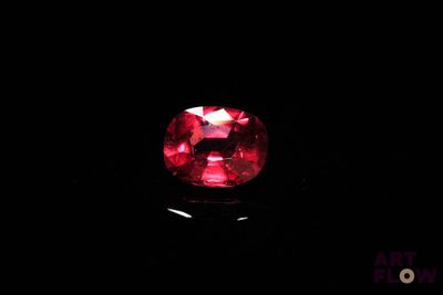 un gros plan sur un diamant rouge dans l'obscurité