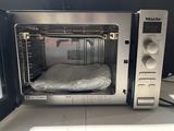 a microwave that has a bag in it on top of it