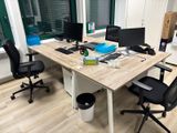 une image représentant un bureau avec deux ordinateurs et une poubelle