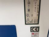a toilet with a blue seat and a sign on the wall